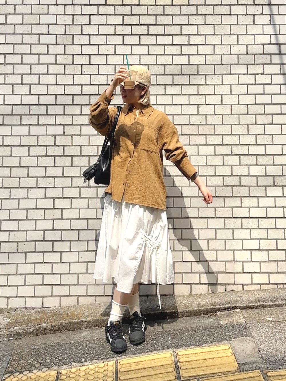 ベージュ系のシャツ/ブラウス、ホワイト系のスカートを着用したレディースの秋コーディネートの3枚目の写真