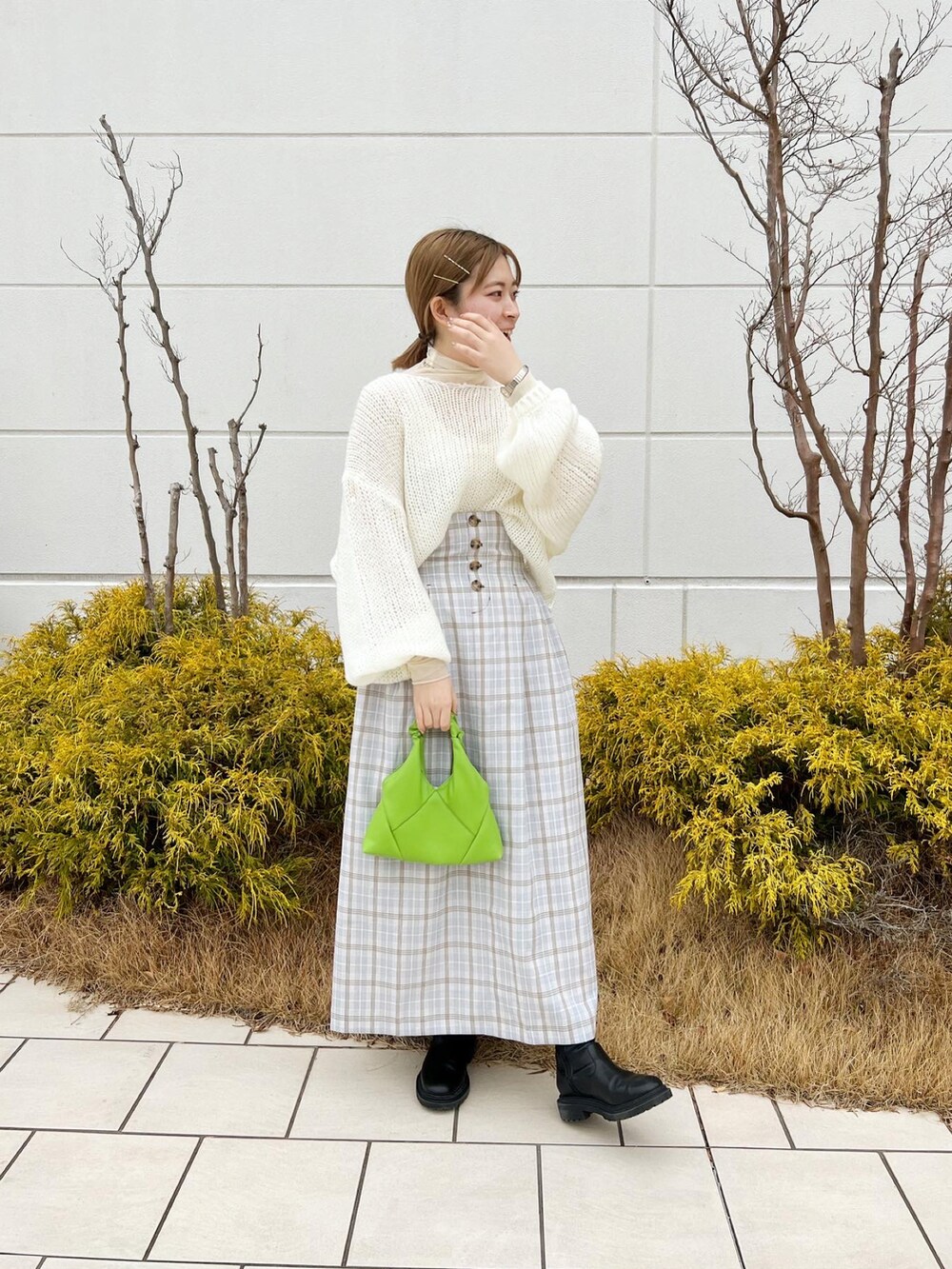 ホワイト系のニット/セーター、パープル系のスカート、ホワイト系のTシャツ/カットソーを着用したレディースの冬コーディネートの5枚目の写真