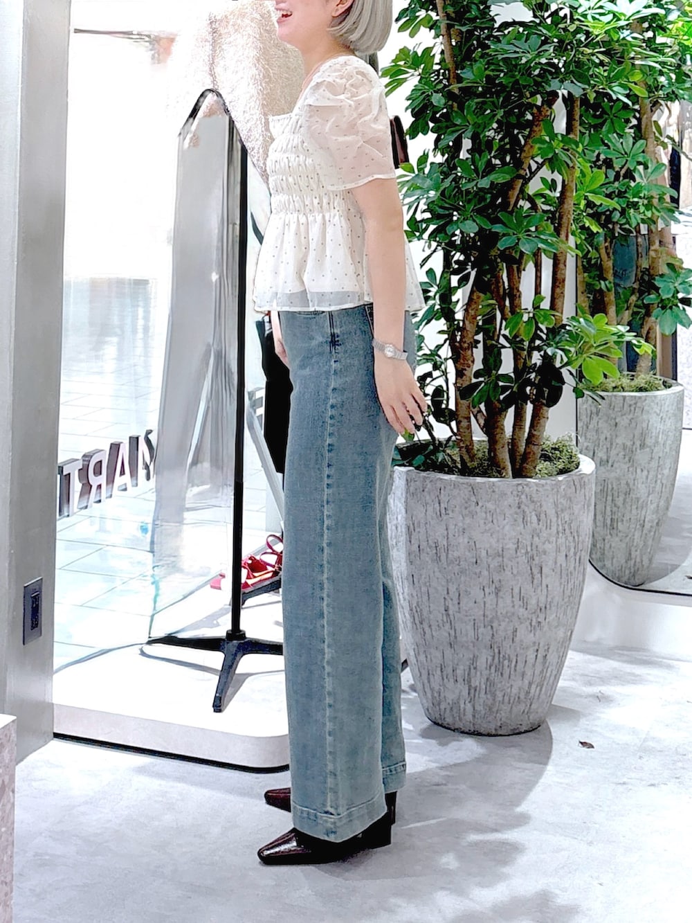 ホワイト系のシャツ/ブラウス、ブラウン系のパンプス、ブルー系のデニムパンツを着用したレディースの秋コーディネートの3枚目の写真