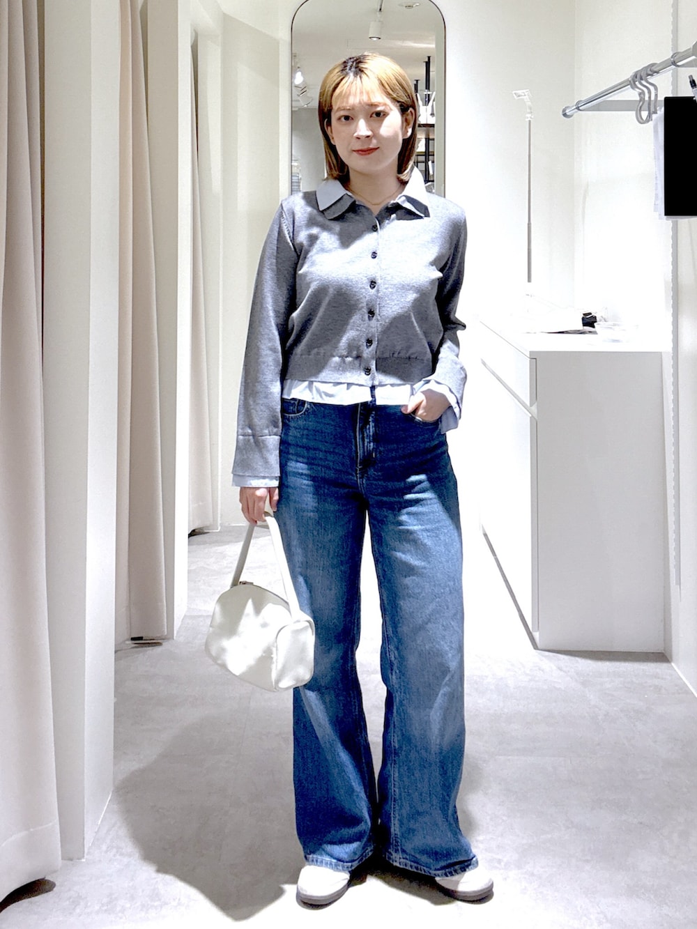 ホワイト系のハンドバッグ、ブルー系のテーラードジャケット、グレー系のニット/セーターを着用したレディースの春コーディネートの7枚目の写真