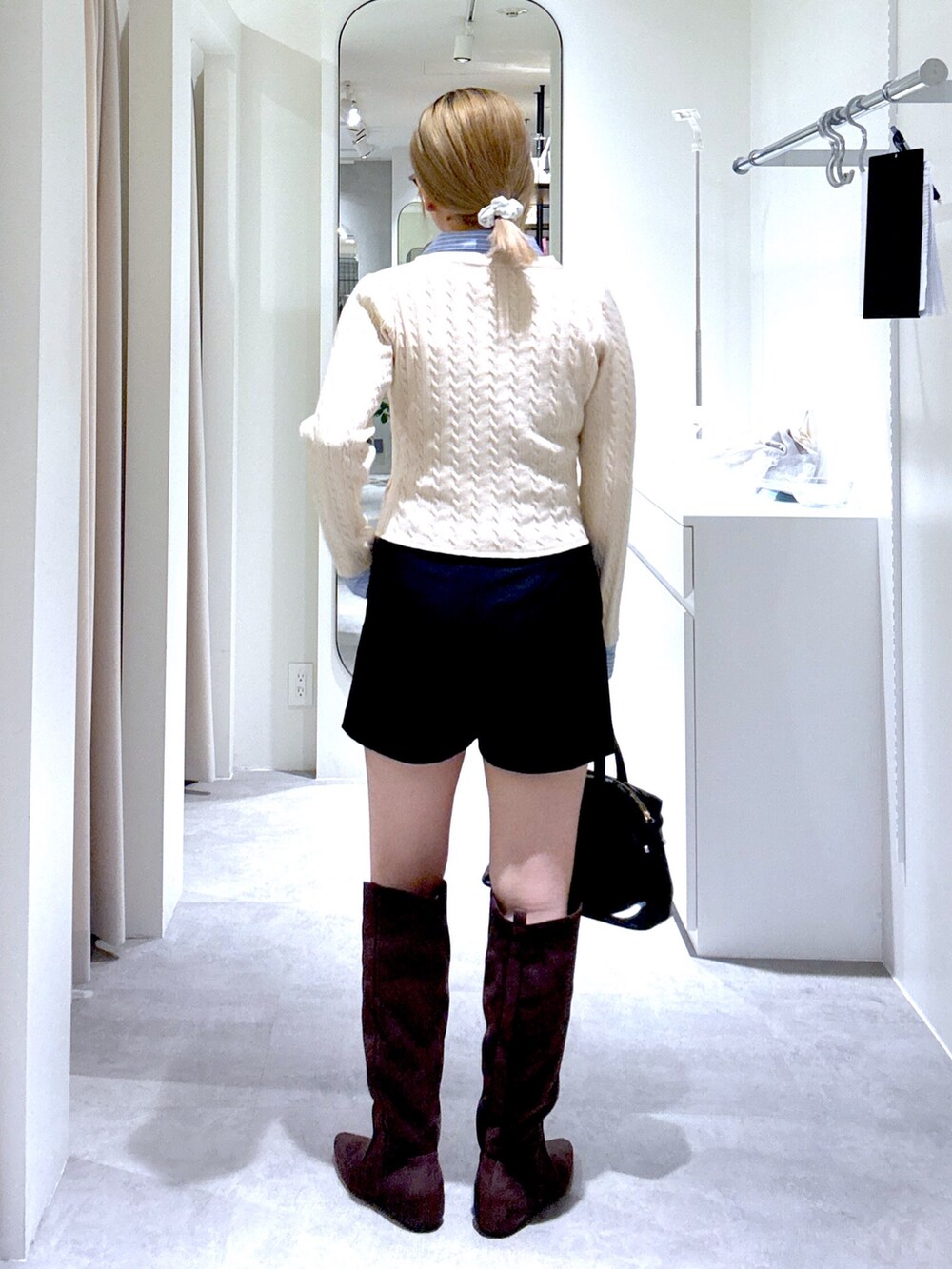 ホワイト系のニット/セーター、ブラック系のその他パンツ、ブラック系のボストンバッグを着用したレディースの冬コーディネートの4枚目の写真