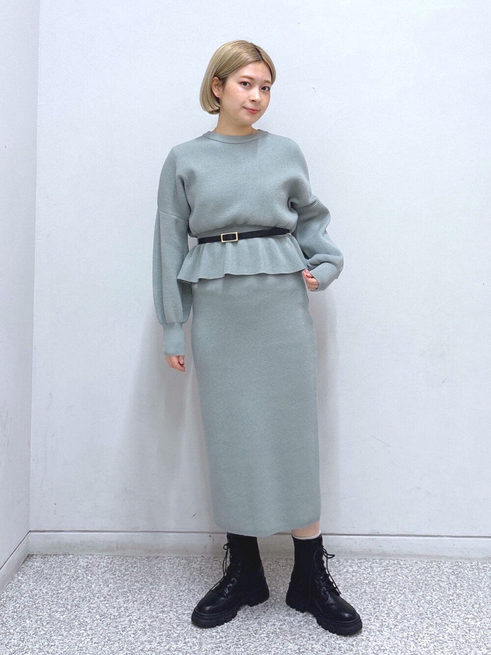 グリーン系のワンピース、ホワイト系のその他アウター、ブラック系のベルトを着用したレディースの冬コーディネートの3枚目の写真