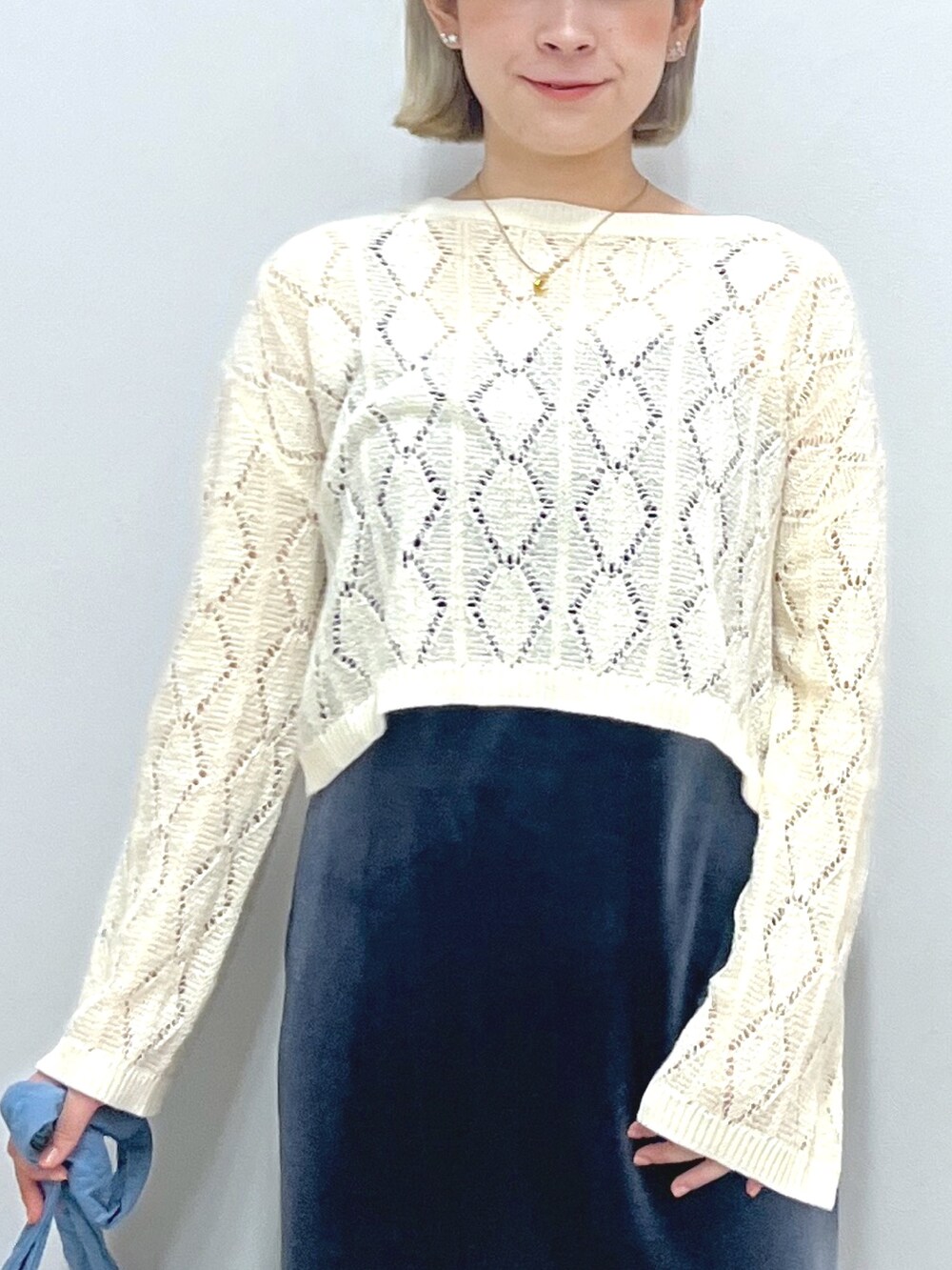 グレー系のワンピース、ホワイト系のニット/セーター、ブルー系のハンドバッグを着用したレディースの秋コーディネートの5枚目の写真