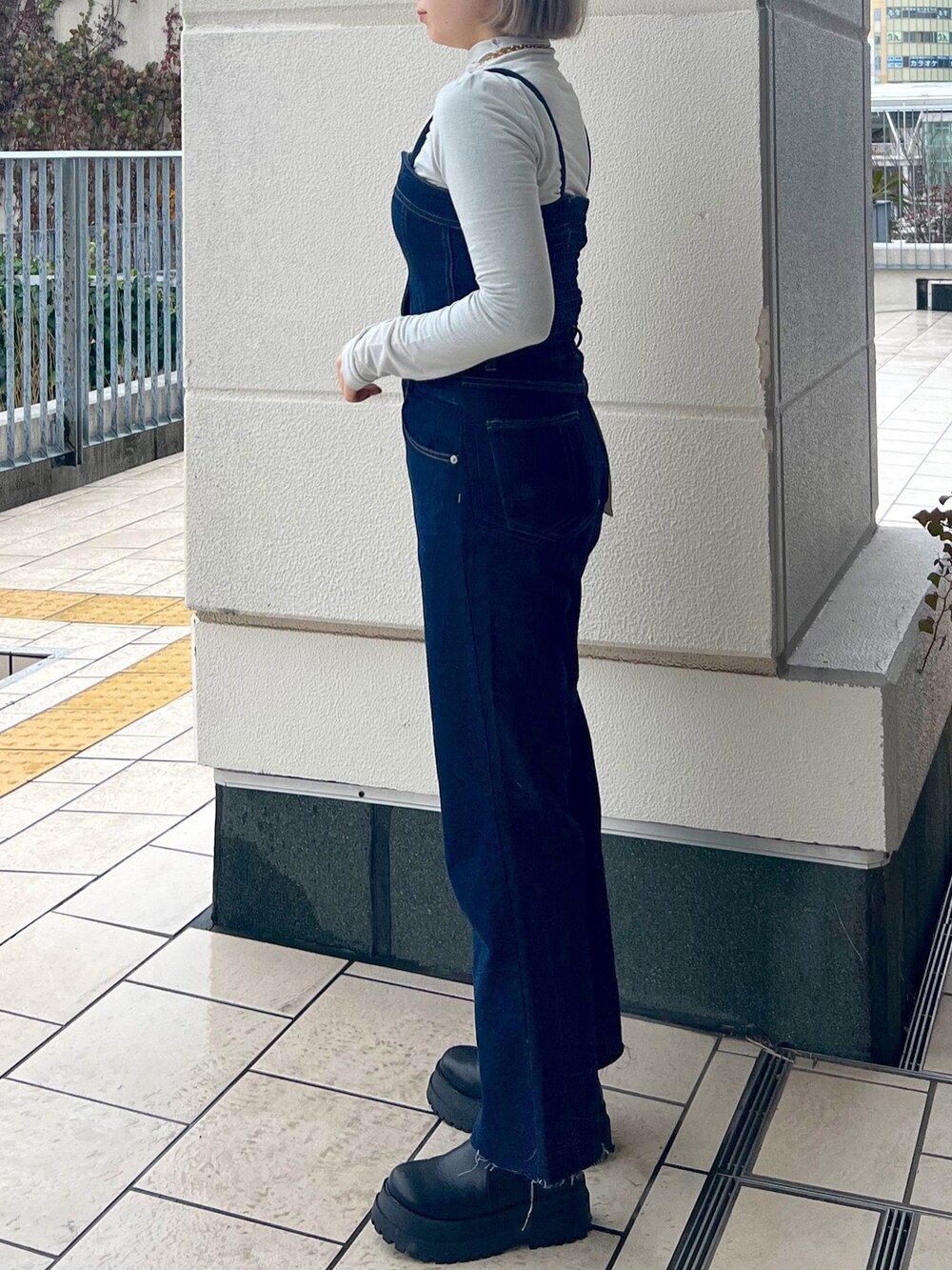 ブルー系のデニムパンツ、ホワイト系のTシャツ/カットソー、ブルー系のベストを着用したレディースの冬コーディネートの3枚目の写真