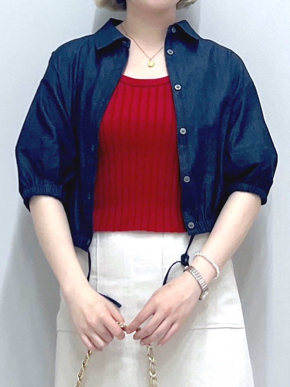 ホワイト系のスカート、ベージュ系のトートバッグ、レッド系のタンクトップを着用したレディースの秋コーディネートの4枚目の写真