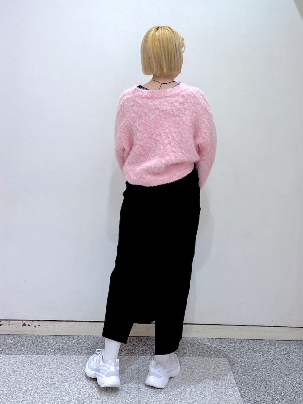 ピンク系のニット/セーター、ブラック系のスカート、ブラック系のショルダーバッグを着用したレディースの冬コーディネートの3枚目の写真