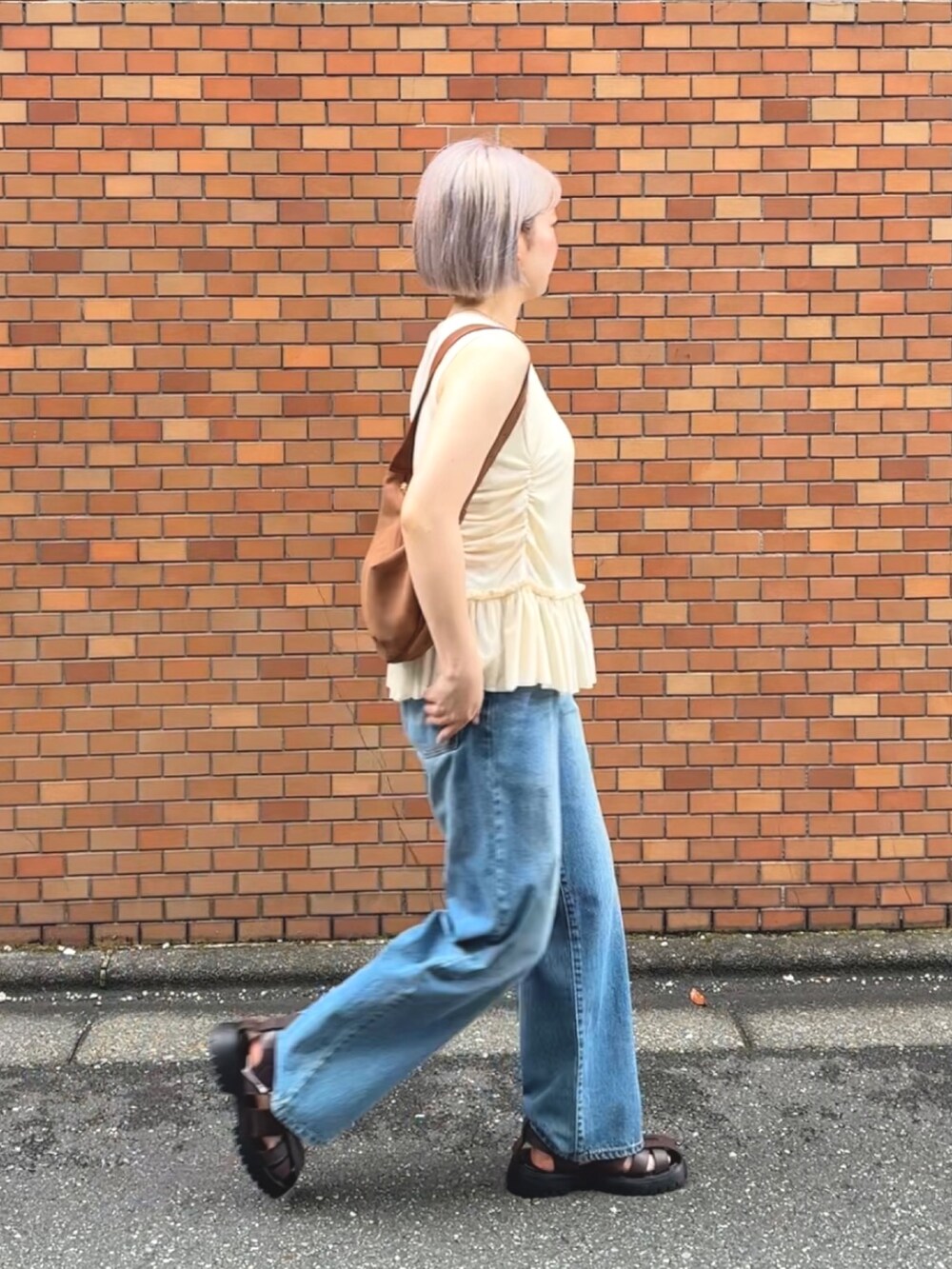 イエロー系のTシャツ/カットソー、ブルー系のデニムパンツ、ブラウン系のサンダルを着用したレディースの夏コーディネートの5枚目の写真
