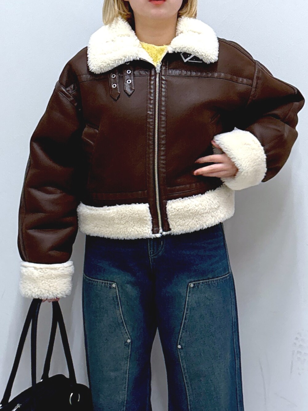 ブルー系のデニムパンツ、ブラウン系のその他アウター、ブラック系のトートバッグを着用したレディースの冬コーディネートの4枚目の写真