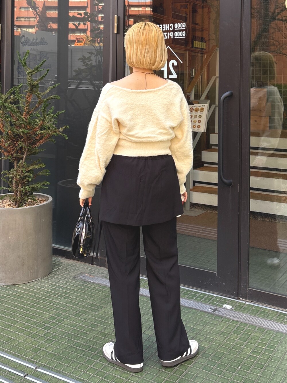 ブラック系のその他パンツ、ホワイト系のニット/セーター、ブラック系のショルダーバッグを着用したレディースの春コーディネートの3枚目の写真