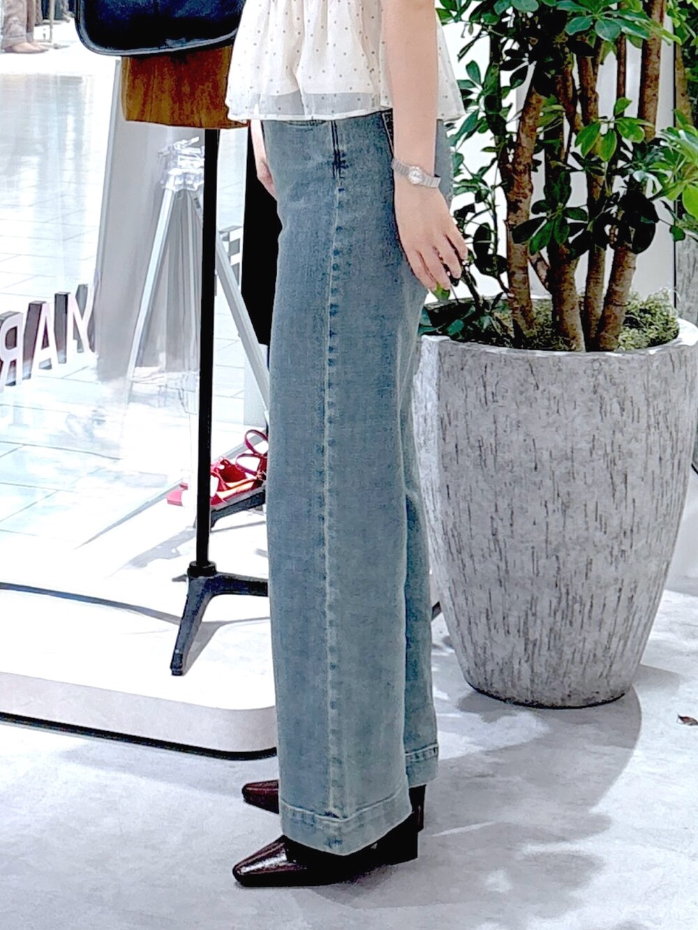 ホワイト系のシャツ/ブラウス、ブラウン系のパンプス、ブルー系のデニムパンツを着用したレディースの秋コーディネートの6枚目の写真