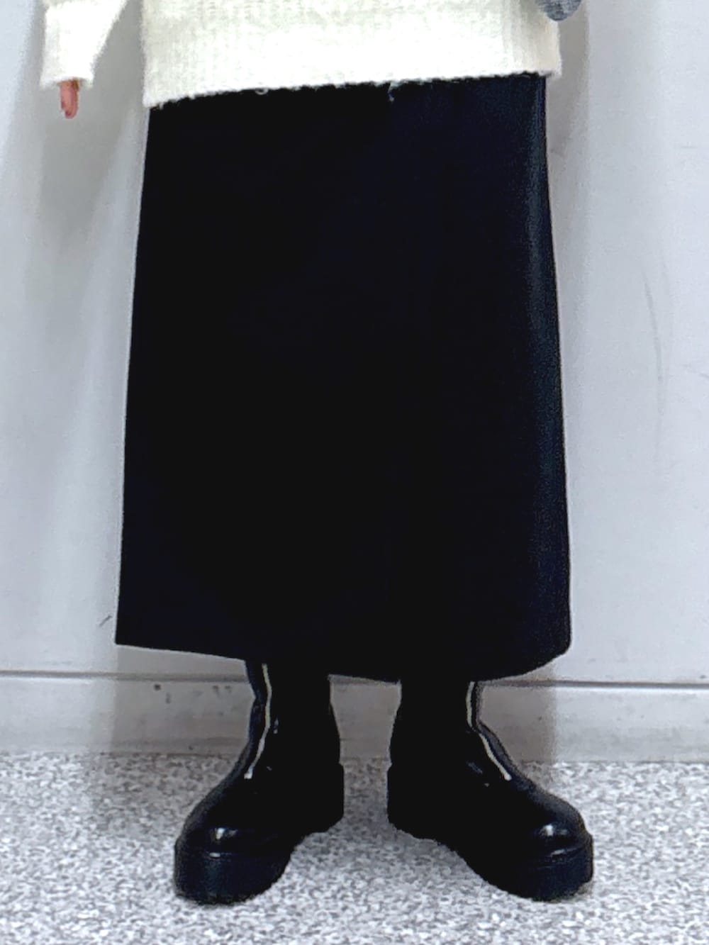 ブラック系のスカート、ホワイト系のニット/セーター、シルバー系のショルダーバッグを着用したレディースの冬コーディネートの6枚目の写真