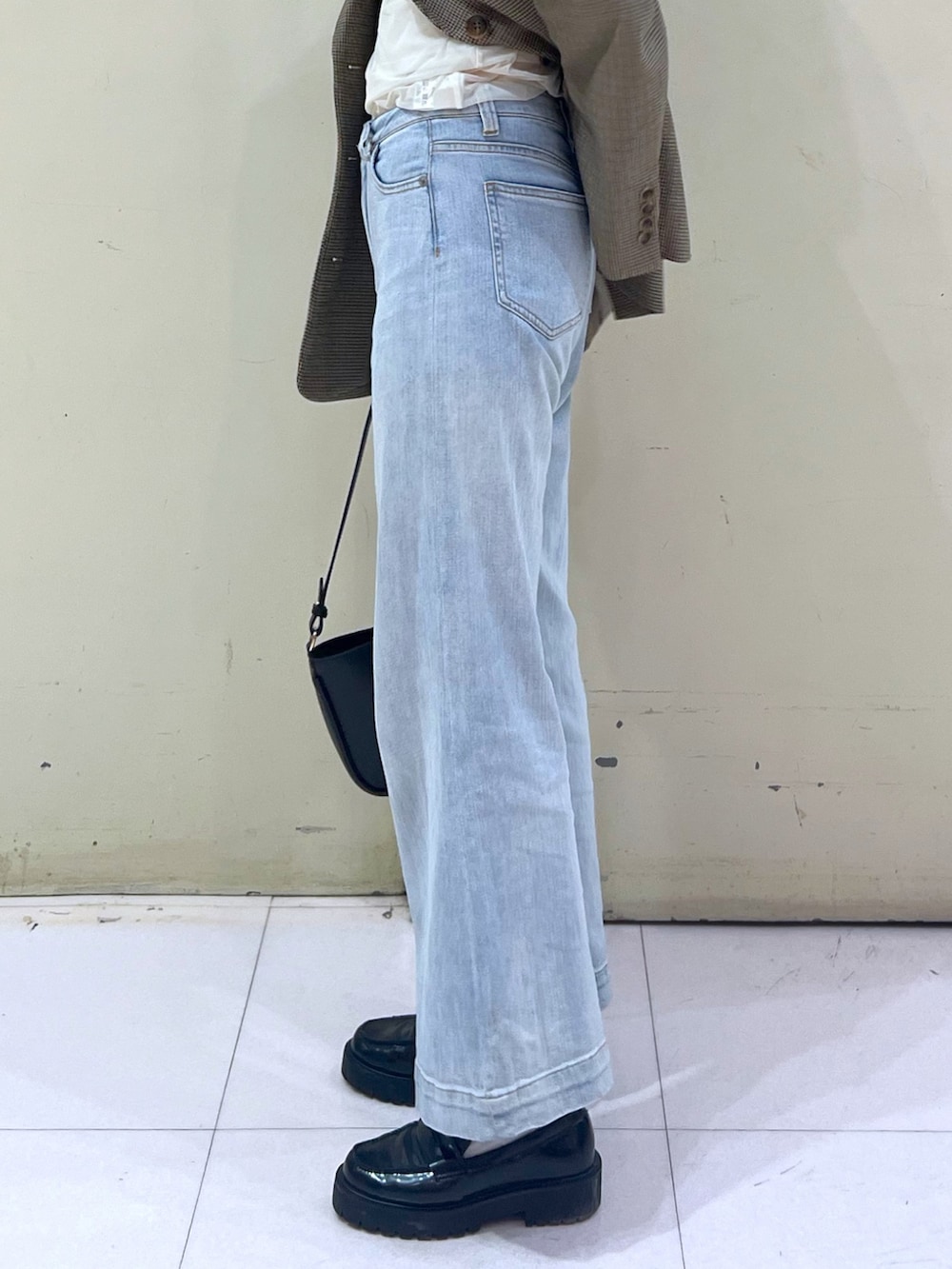 ブラウン系のテーラードジャケット、ホワイト系のTシャツ/カットソー、ベージュ系のショルダーバッグを着用したレディースの春コーディネートの6枚目の写真