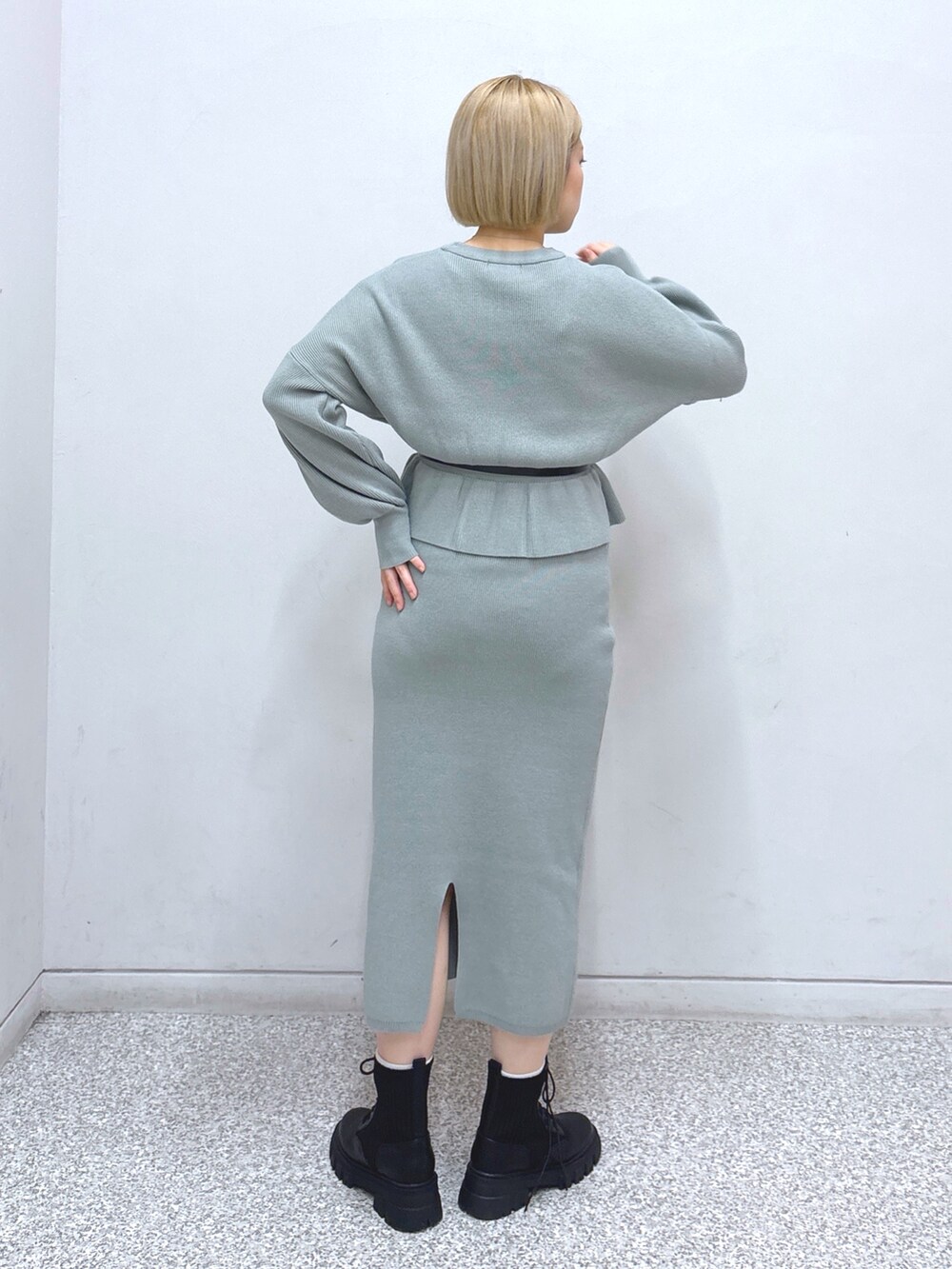 グリーン系のワンピース、ホワイト系のその他アウター、ブラック系のベルトを着用したレディースの冬コーディネートの5枚目の写真