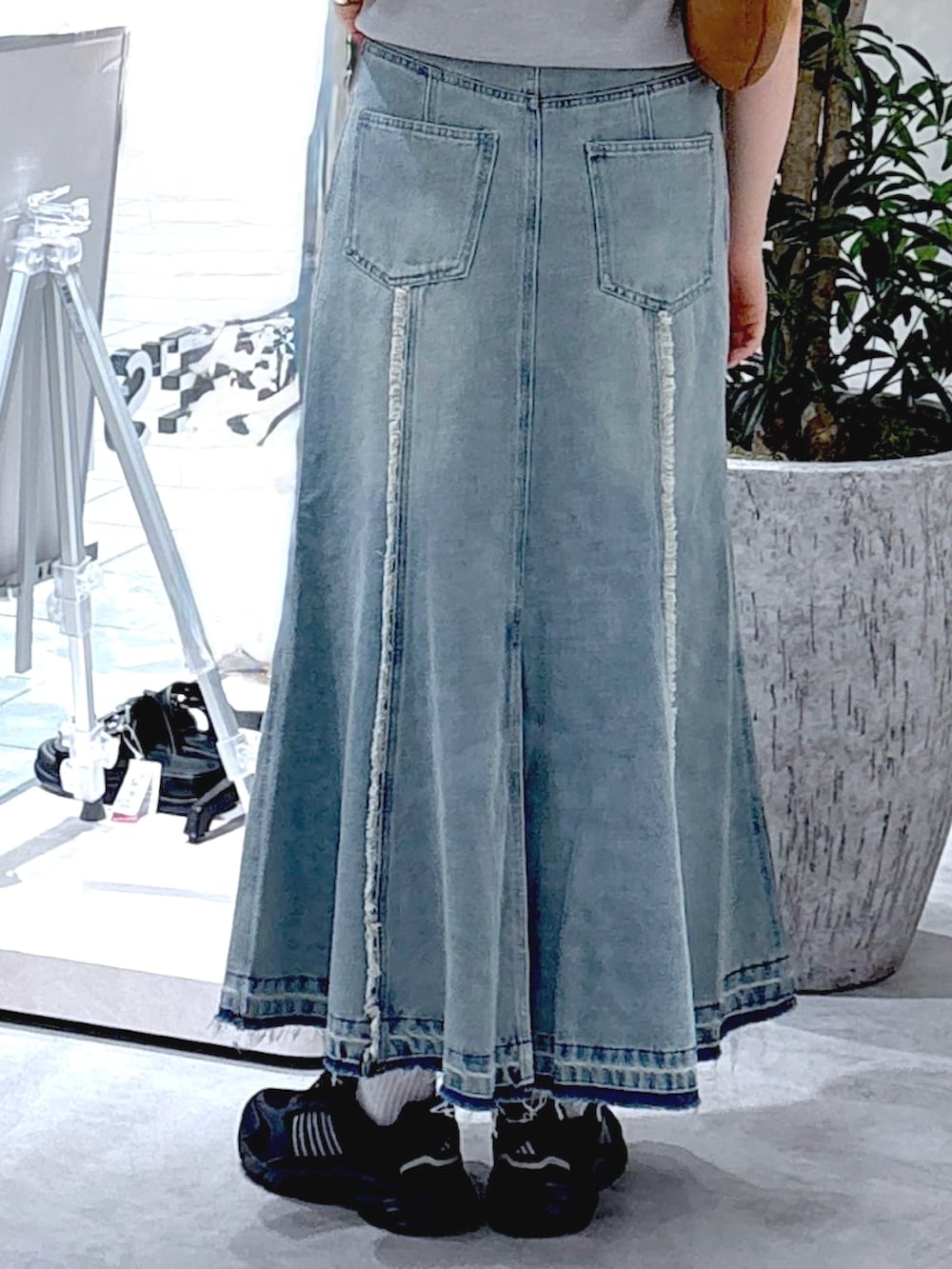 グレー系のニット/セーター、ブルー系のスカート、ブラウン系のハンドバッグを着用したレディースの夏コーディネートの5枚目の写真