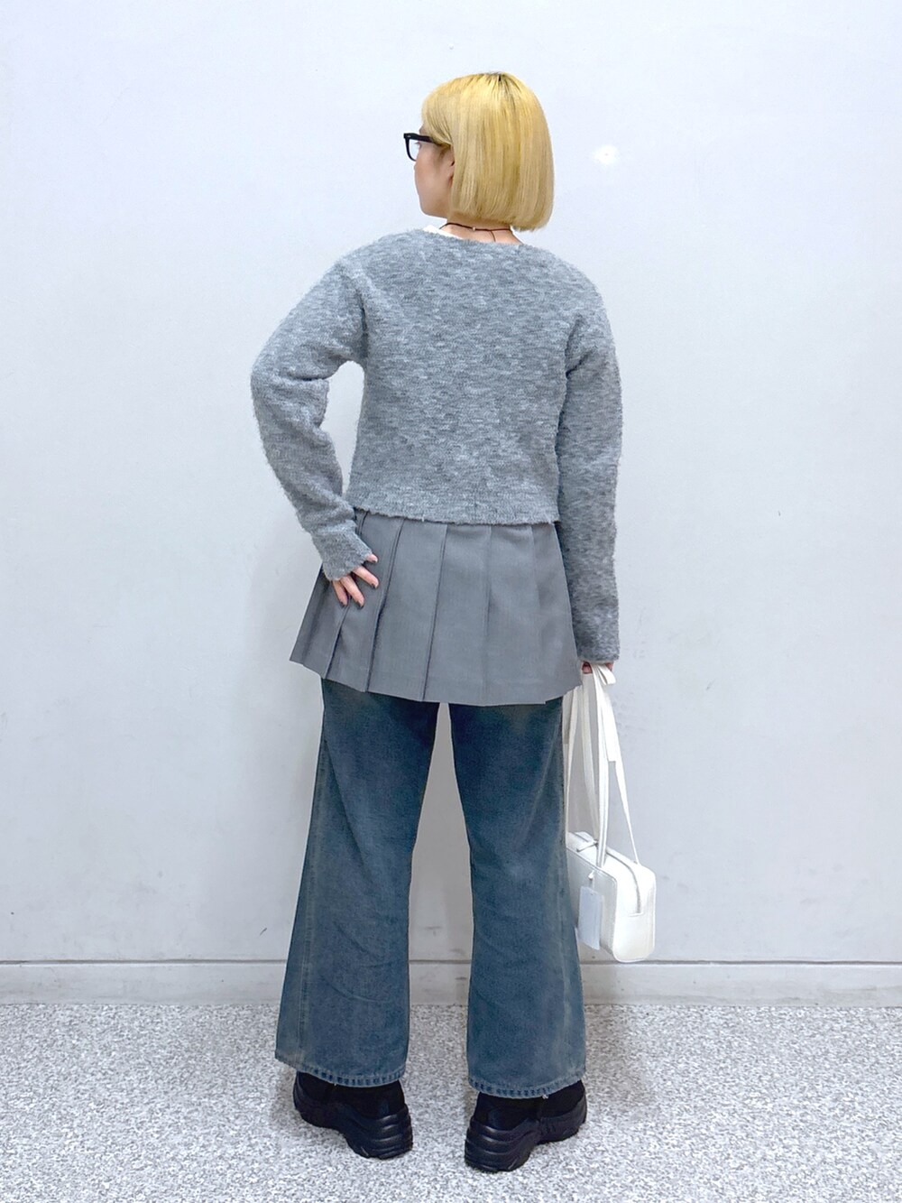 ブルー系のデニムパンツ、グレー系のスカート、グレー系のカーディガン/ボレロを着用したレディースの春コーディネートの3枚目の写真