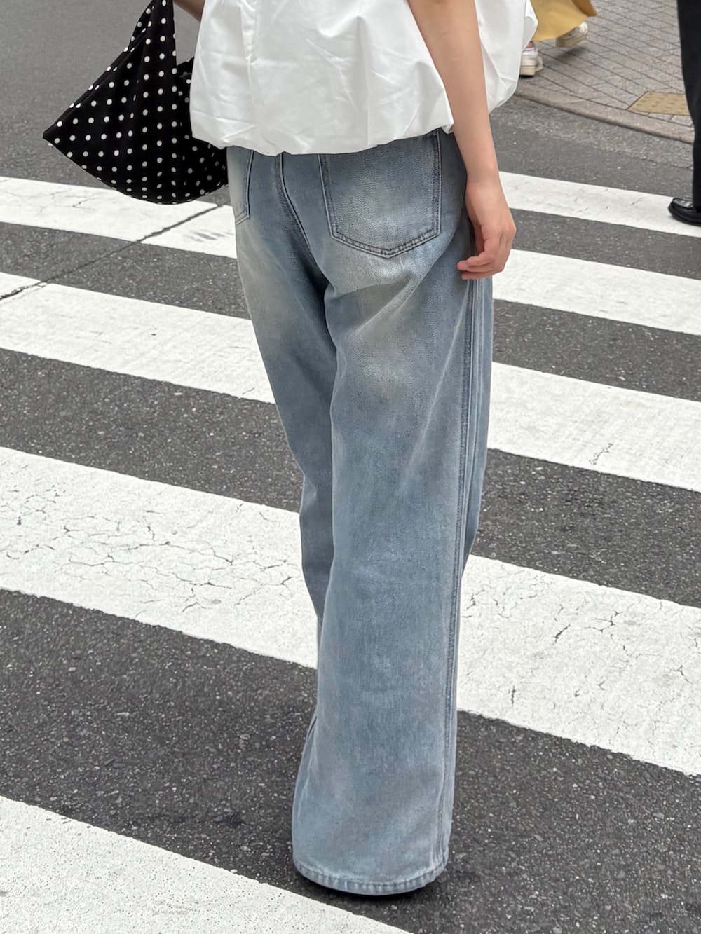 ブルー系のデニムパンツを着用したレディースの夏コーディネートの4枚目の写真
