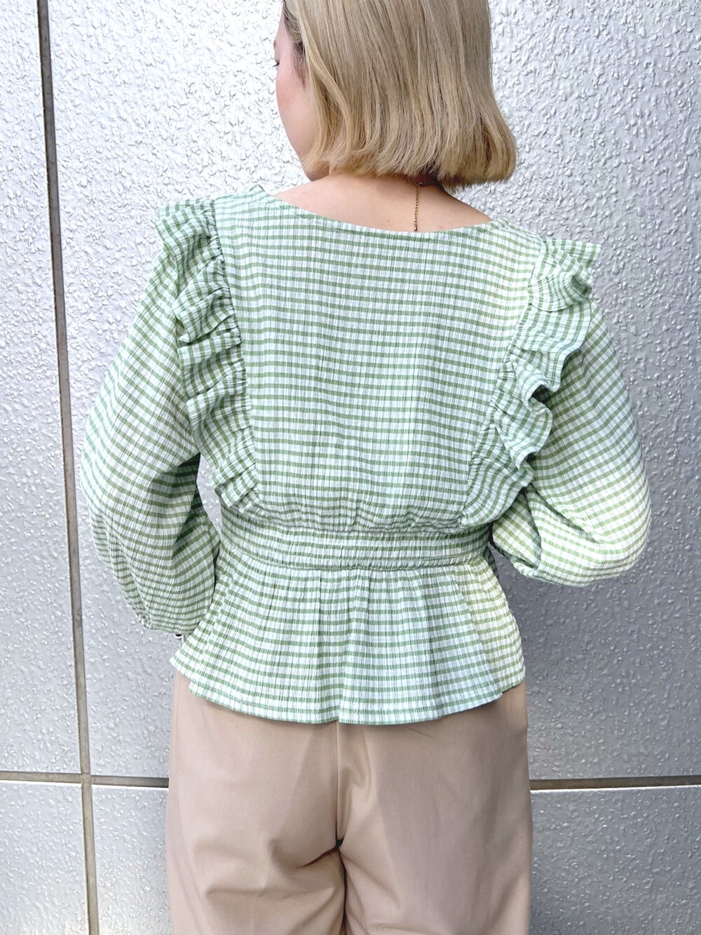 グリーン系のシャツ/ブラウス、ベージュ系のショルダーバッグ、ベージュ系のスラックスを着用したレディースの春コーディネートの6枚目の写真