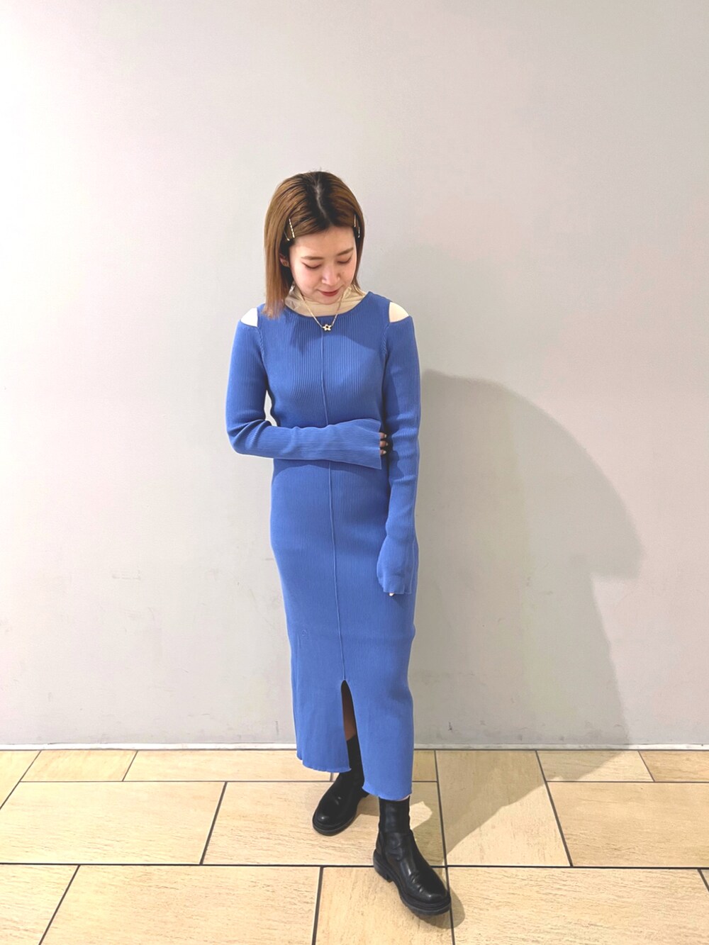 ベージュ系のトレンチコート、ブルー系のワンピース、ホワイト系のTシャツ/カットソーを着用したレディースの冬コーディネートの2枚目の写真