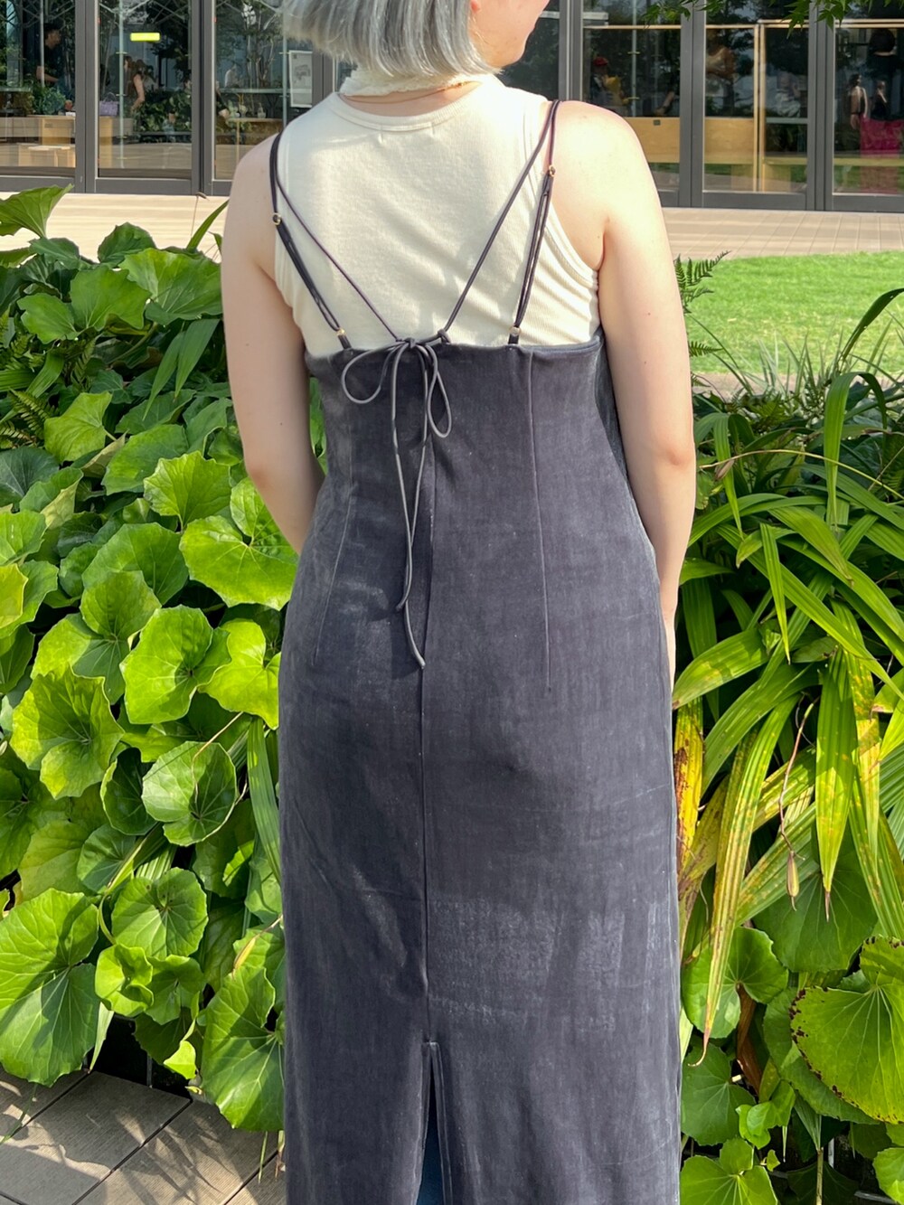 シルバー系のハンドバッグ、ブルー系のデニムパンツ、ホワイト系のタンクトップを着用したレディースの秋コーディネートの5枚目の写真