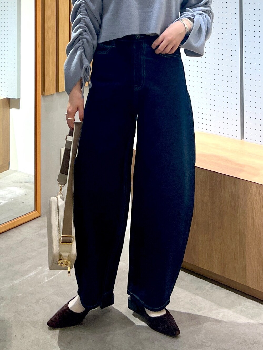 ブルー系のデニムパンツ、グレー系のボディバッグ/ウエストポーチ、ブルー系のワンピースを着用したレディースの冬コーディネートの5枚目の写真