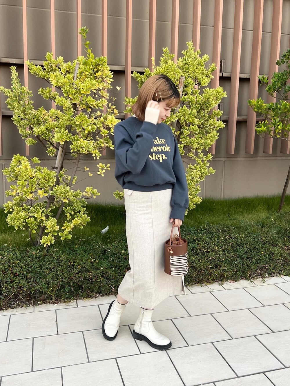 ベージュ系のショルダーバッグ、ブルー系のTシャツ/カットソー、ホワイト系のTシャツ/カットソーを着用したレディースの秋コーディネートの2枚目の写真