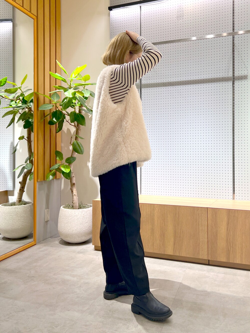 ブラック系のショルダーバッグ、ホワイト系のベスト、ホワイト系のニット/セーターを着用したレディースの秋コーディネートの3枚目の写真