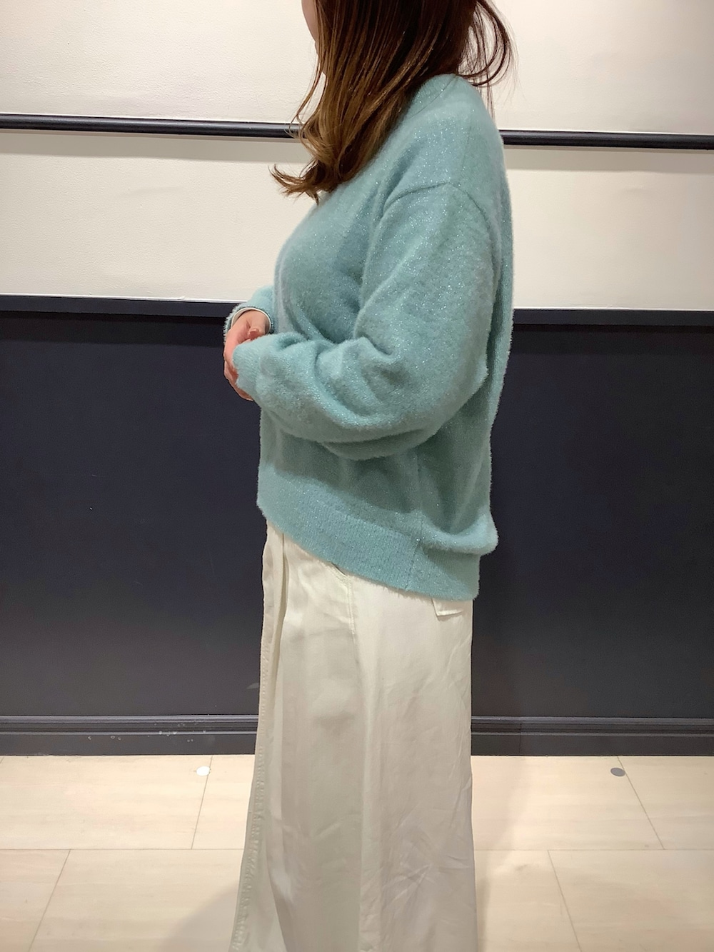 ブルー系のニット/セーターを着用したレディースの冬コーディネートの2枚目の写真