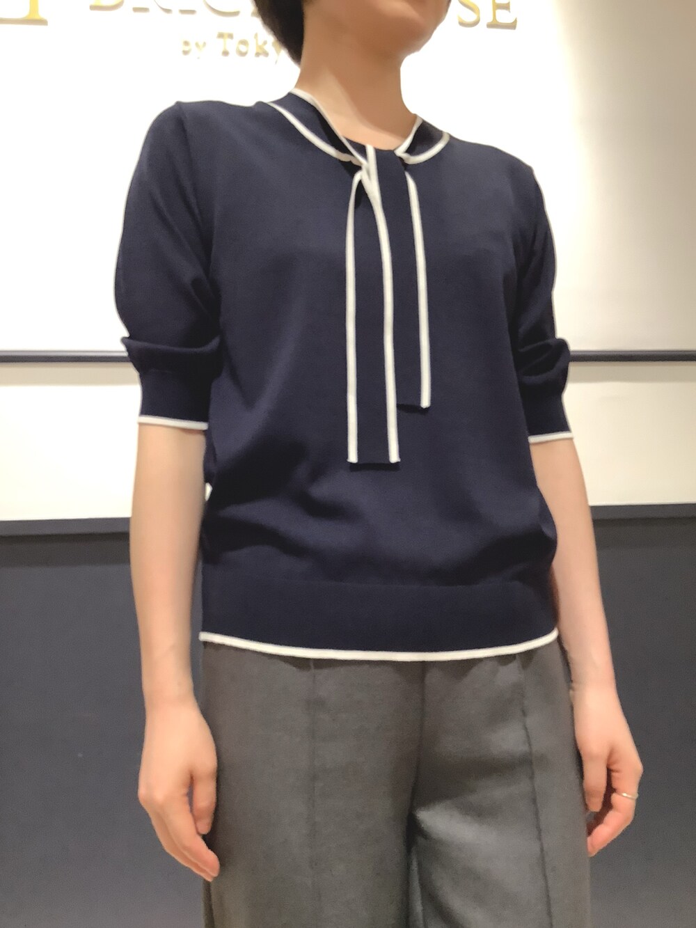 ブルー系のニット/セーターを着用したレディースの夏コーディネートの2枚目の写真