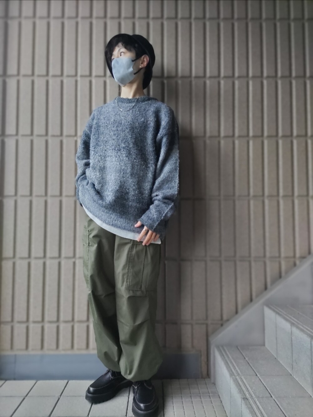 ブラック系のニット/セーター、ホワイト系のタンクトップ、ブラック系のカーゴパンツを着用したメンズの秋コーディネートの2枚目の写真