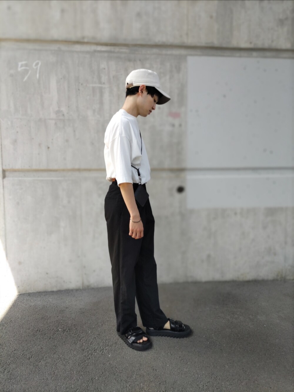 ホワイト系のTシャツ/カットソー、ブラック系のパンツ、ブラック系のサンダルを着用したメンズの秋コーディネートの2枚目の写真