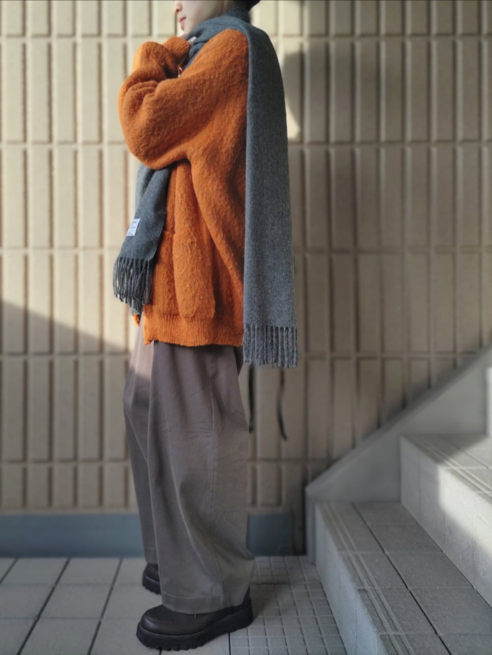 オレンジ系のカーディガン/ボレロ、グレー系のシャツ/ブラウス、グレー系のその他パンツを着用したメンズの冬コーディネートの3枚目の写真