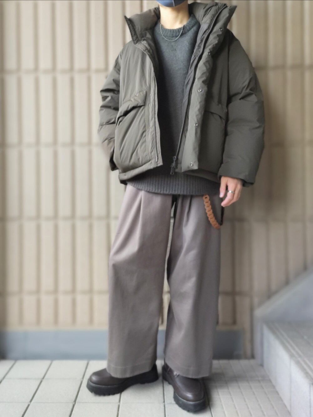 グリーン系のダウンジャケット/コート、グリーン系のニット/セーター、グレー系のその他パンツを着用したメンズの冬コーディネートの2枚目の写真