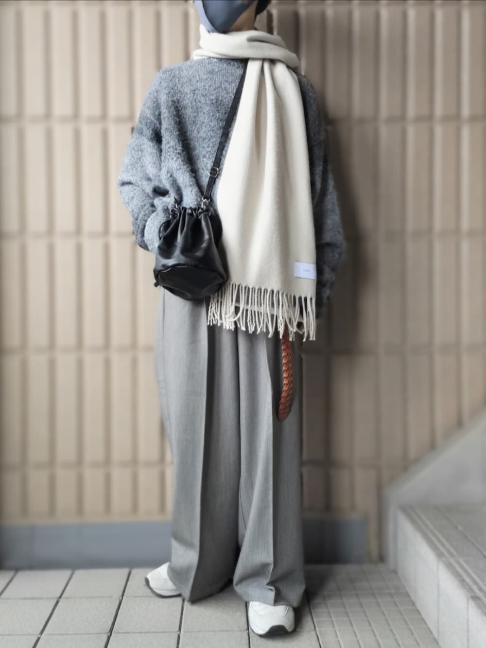 ブラック系のニット/セーター、グレー系のスラックス、ホワイト系のスニーカーを着用したメンズの冬コーディネートの2枚目の写真