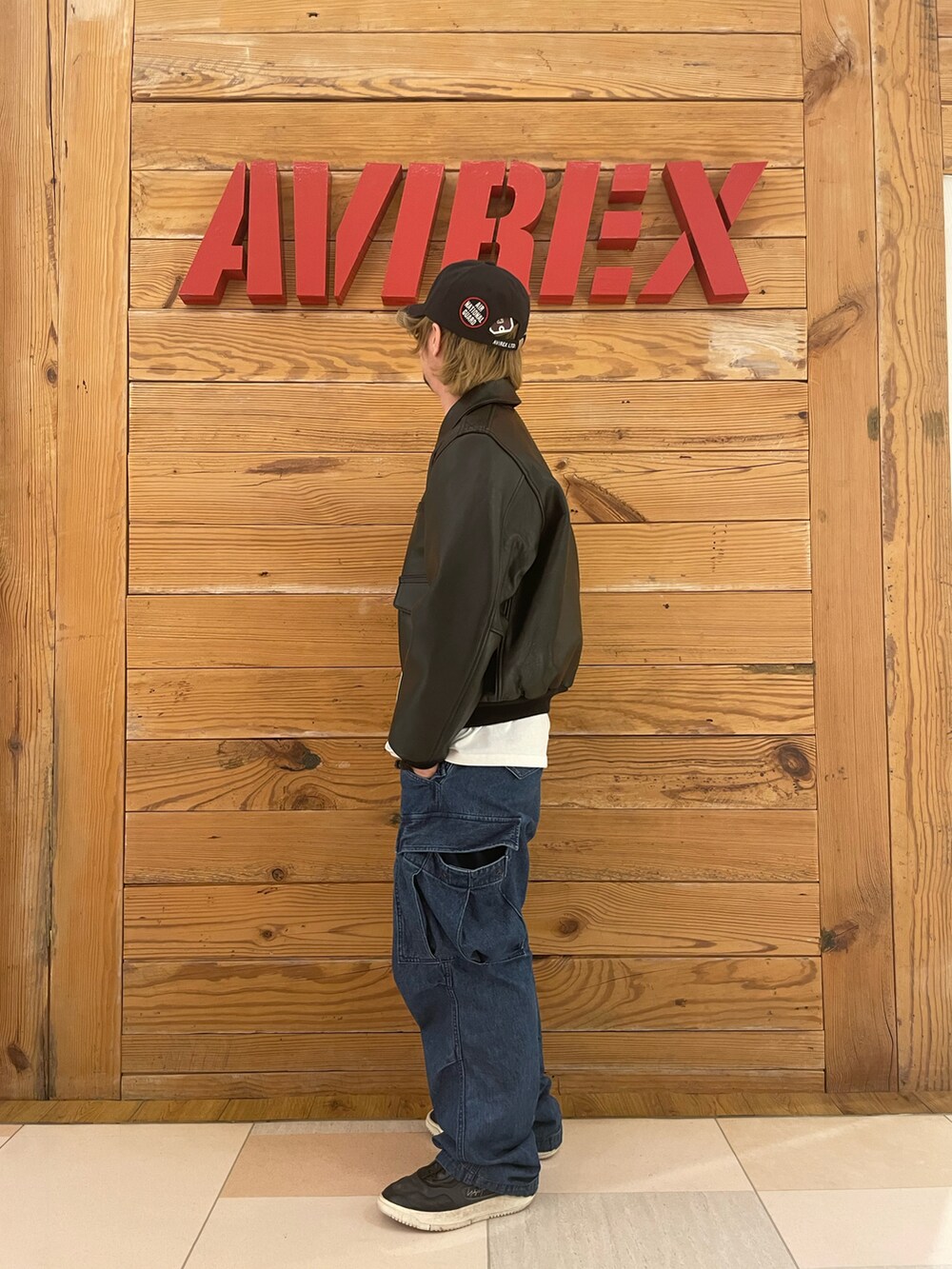 ホワイト系のTシャツ/カットソー、その他のカーゴパンツ、ブラック系のミリタリージャケットを着用したメンズの冬コーディネートの2枚目の写真