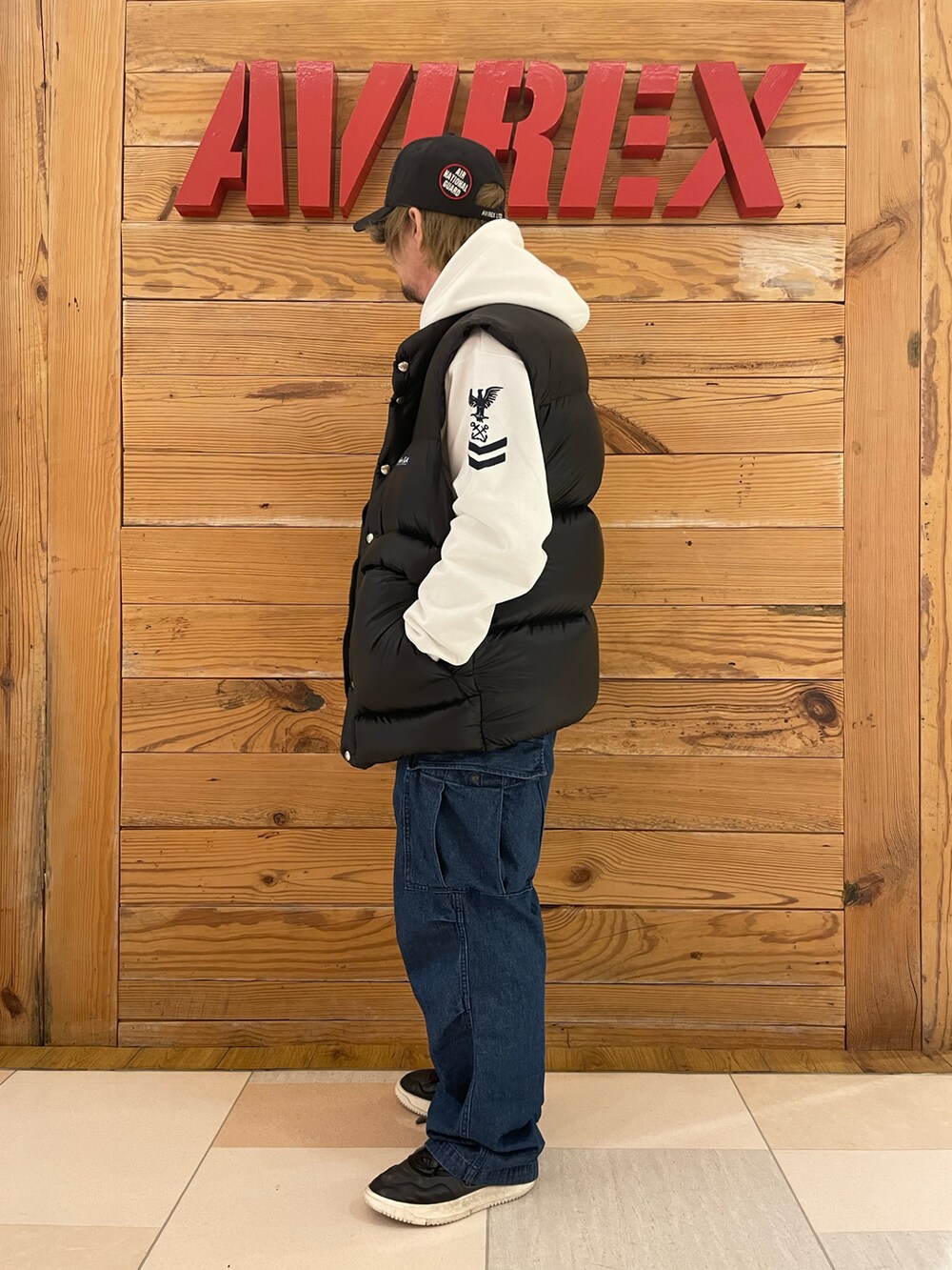 「ダウンベスト、パーカー、AVIREX、黒キャップ、白パーカー、AVIREXBelle、デニムカーゴパンツ、AVIREX町田店、ファッションの力を信じよう、AVIREX町田」｜「AVIREXのAIR NATIONALＮ GUARD CAP / エアナショナルガード キャップ / AVIREX / アヴィレックス（キャップ、ブラック系）」を使った、TOMさん（メンズ・161cm）の冬コーディネートの2枚目の写真