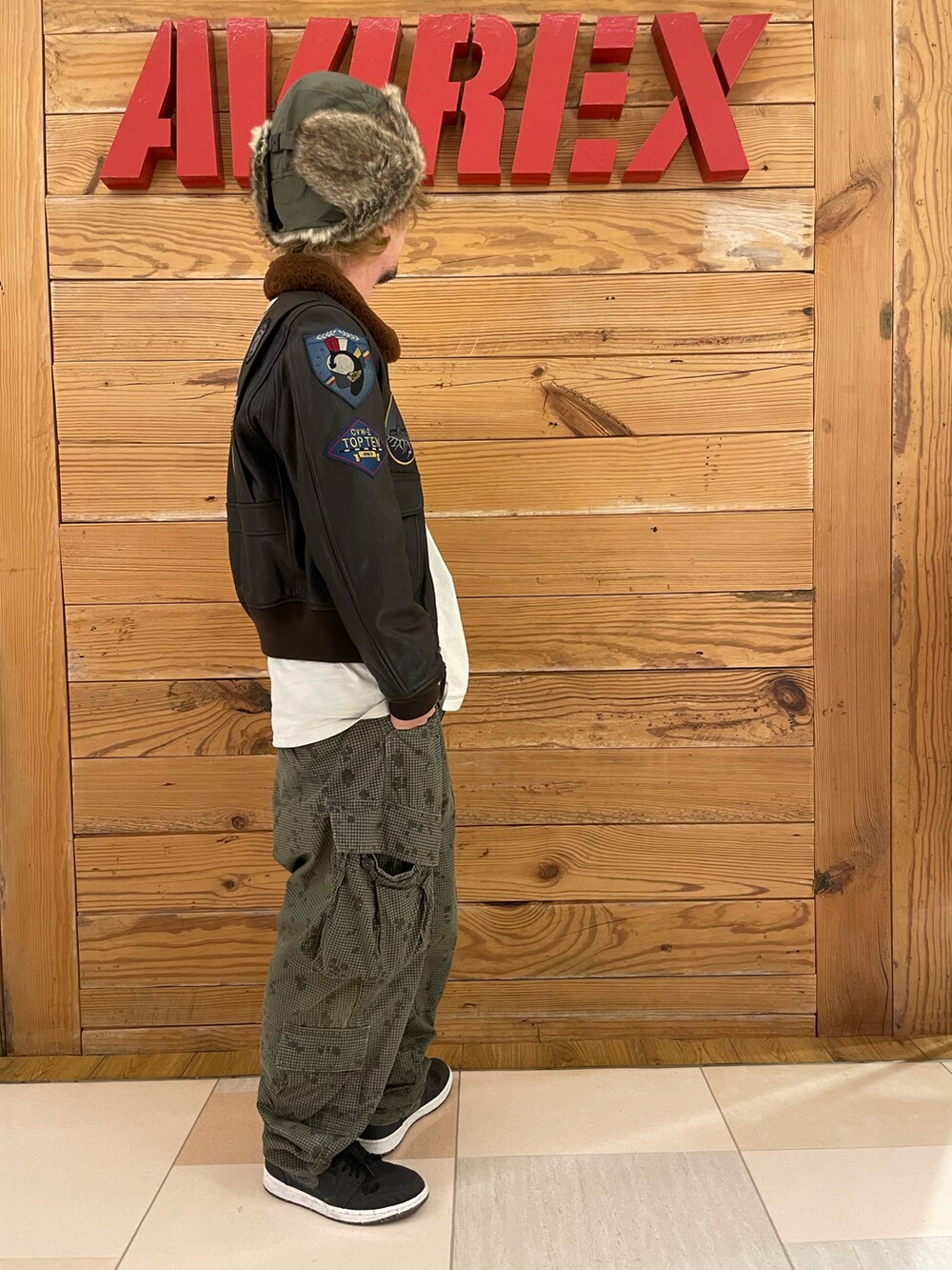 ホワイト系のTシャツ/カットソー、その他のカーゴパンツ、ブラウン系のミリタリージャケットを着用したメンズの冬コーディネートの4枚目の写真