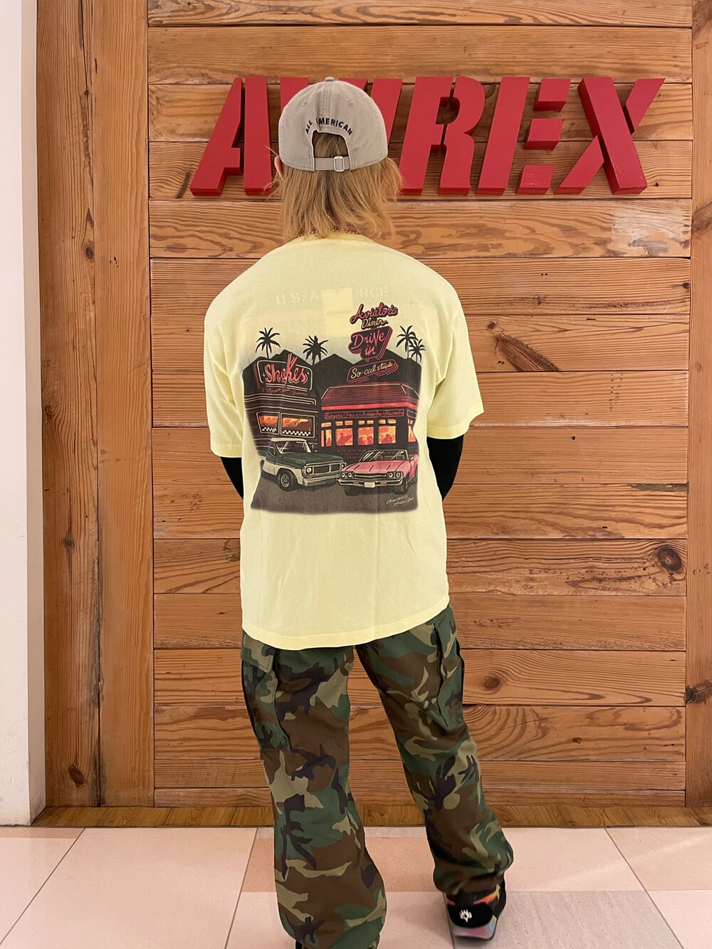 イエロー系のTシャツ/カットソー、グリーン系のカーゴパンツ、その他のキャップを着用したメンズの春コーディネートの3枚目の写真