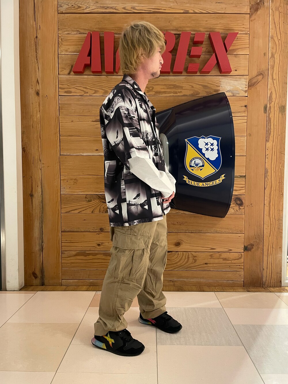 グリーン系のカーゴパンツ、ブラック系のシャツ/ブラウス、ホワイト系のTシャツ/カットソーを着用したメンズの春コーディネートの4枚目の写真