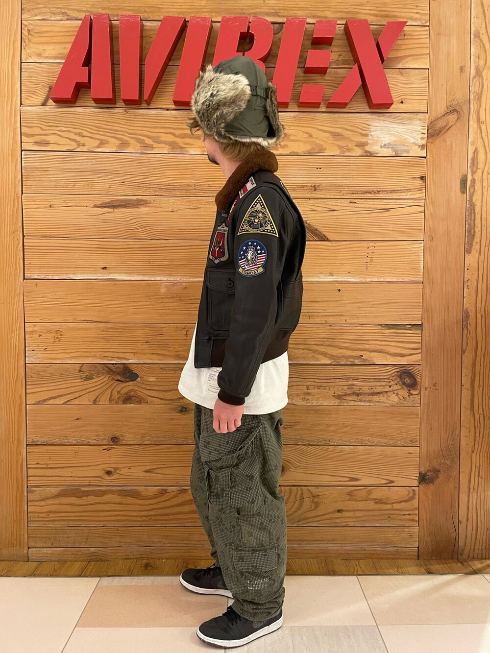 ホワイト系のTシャツ/カットソー、その他のカーゴパンツ、ブラウン系のミリタリージャケットを着用したメンズの冬コーディネートの2枚目の写真