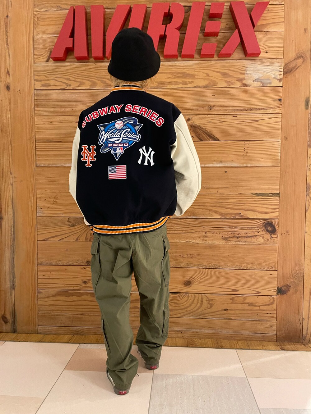 ブルー系のスタジャン、ホワイト系のTシャツ/カットソー、グリーン系のカーゴパンツを着用したメンズの秋コーディネートの3枚目の写真