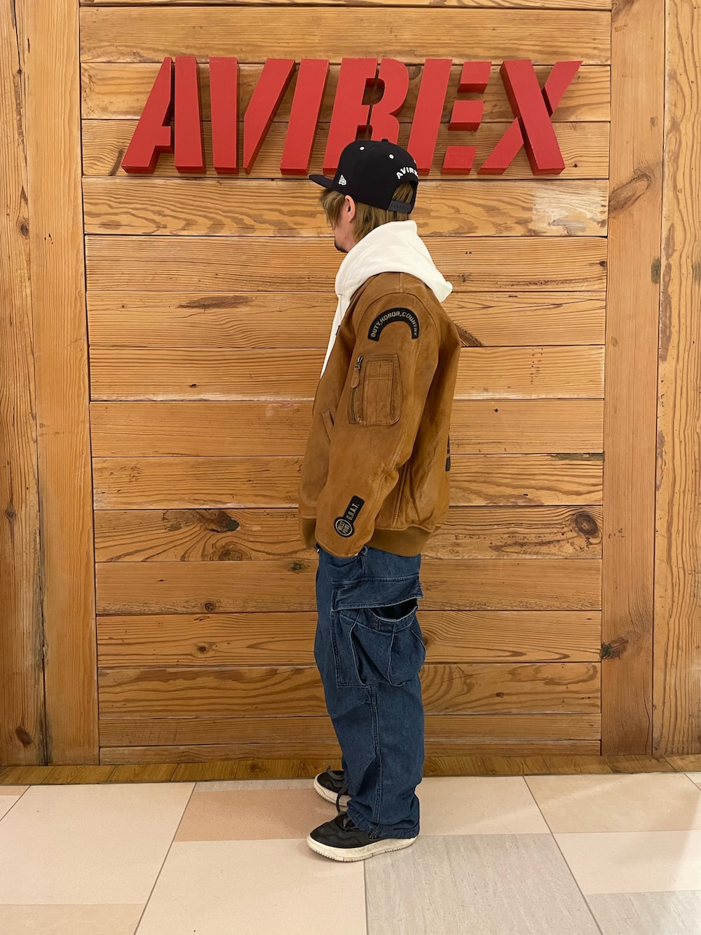 イエロー系のMA-1、その他のカーゴパンツ、ホワイト系のパーカーを着用したメンズの冬コーディネートの3枚目の写真