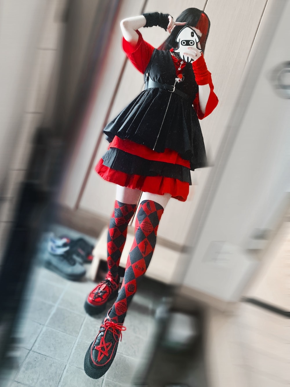 レッド系のTシャツ/カットソー、ブラック系のベスト、ブラック系のスカートを着用したレディースの夏コーディネートの2枚目の写真