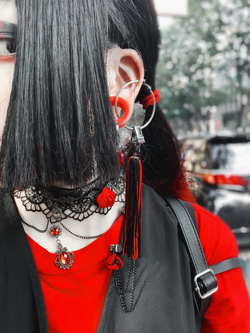 レッド系のTシャツ/カットソー、ブラック系のベスト、ブラック系のスカートを着用したレディースの夏コーディネートの3枚目の写真