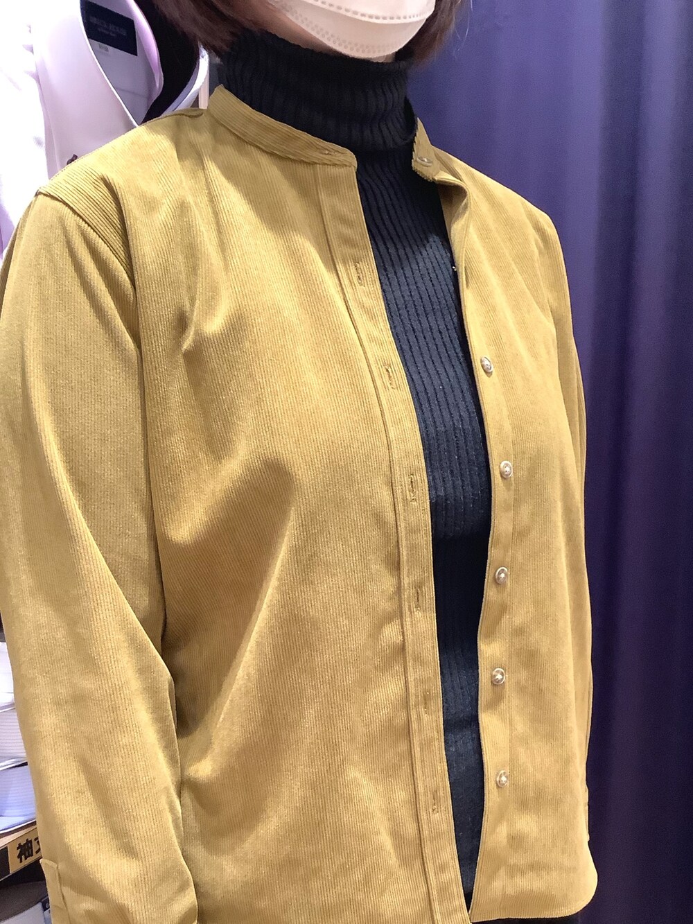 グリーン系のシャツ/ブラウス、ブラック系のニット/セーターを着用したレディースの冬コーディネートの2枚目の写真