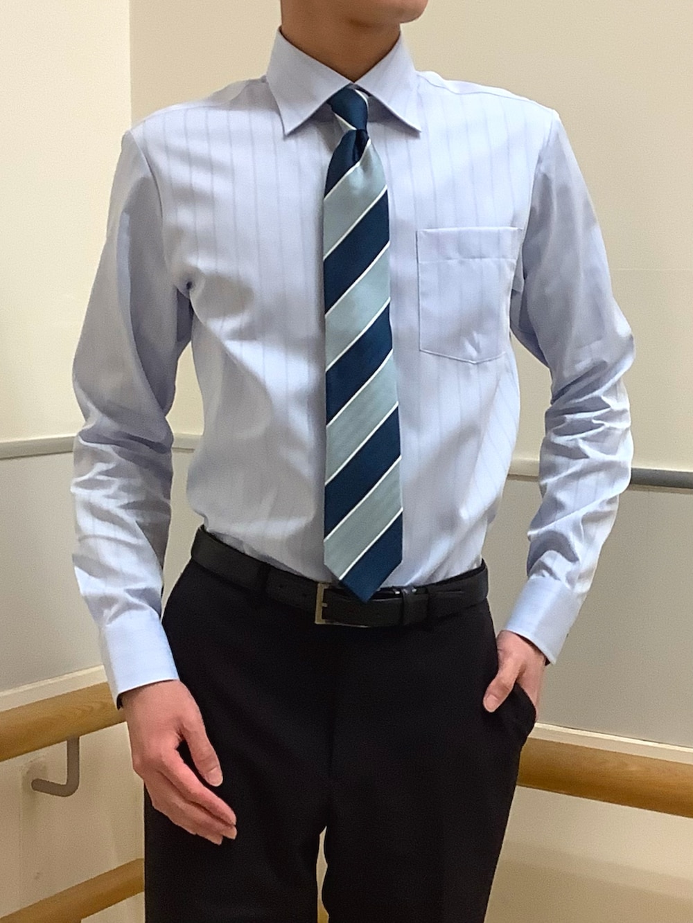 グリーン系のネクタイ、ブルー系のビジネスシャツを着用したメンズの冬コーディネートの2枚目の写真