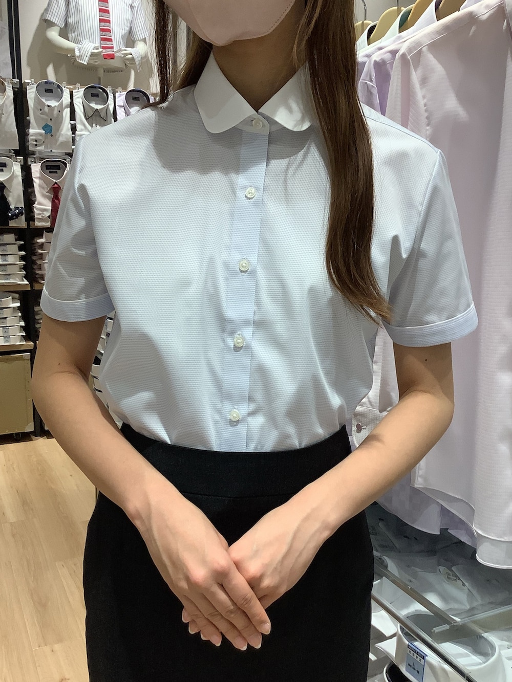 ブルー系のビジネスシャツを着用したレディースの夏コーディネートの2枚目の写真