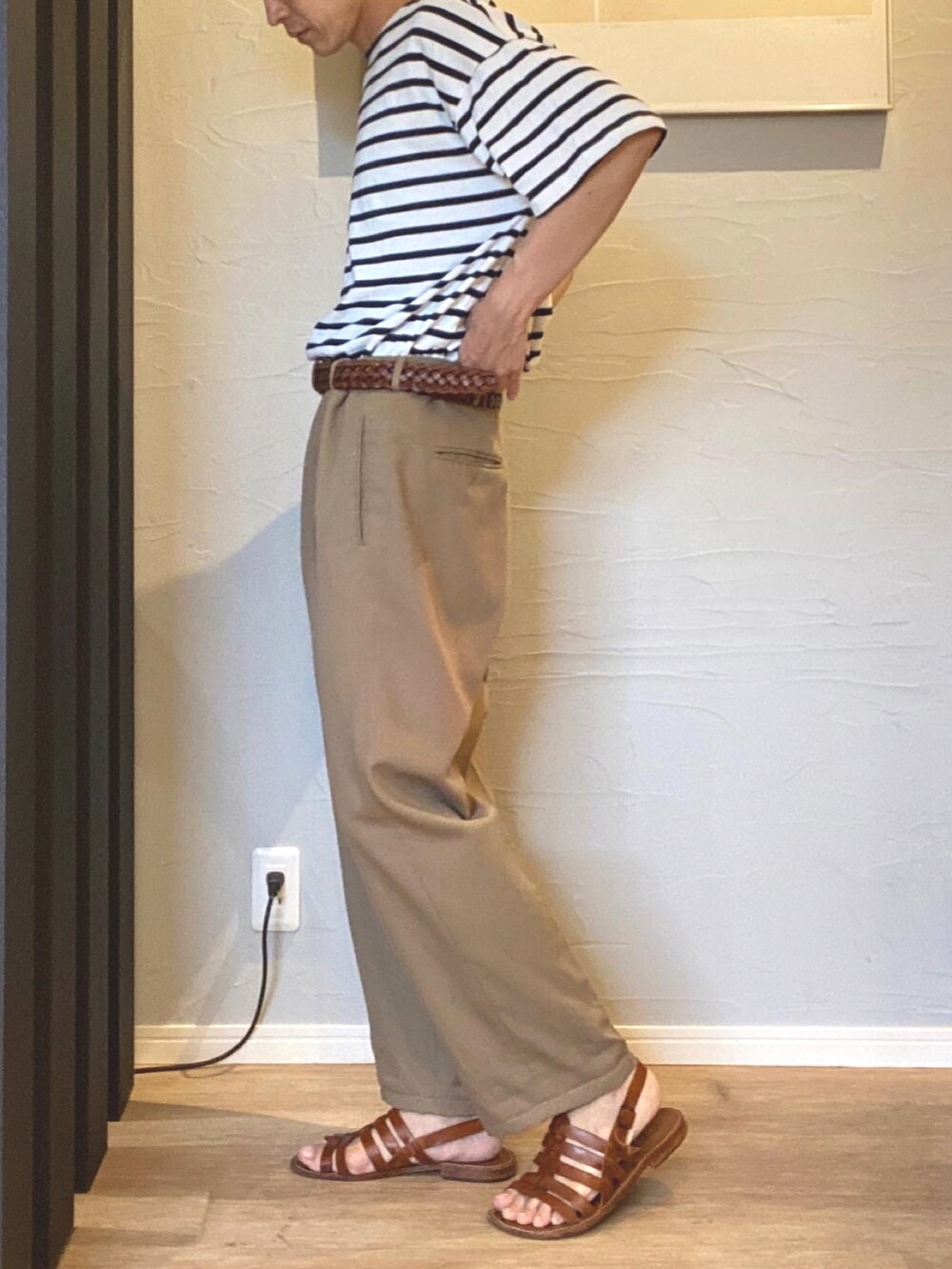 ホワイト系のトップス、ベージュ系のチノパンツ、ブラウン系のサンダルを着用したメンズの夏コーディネートの2枚目の写真