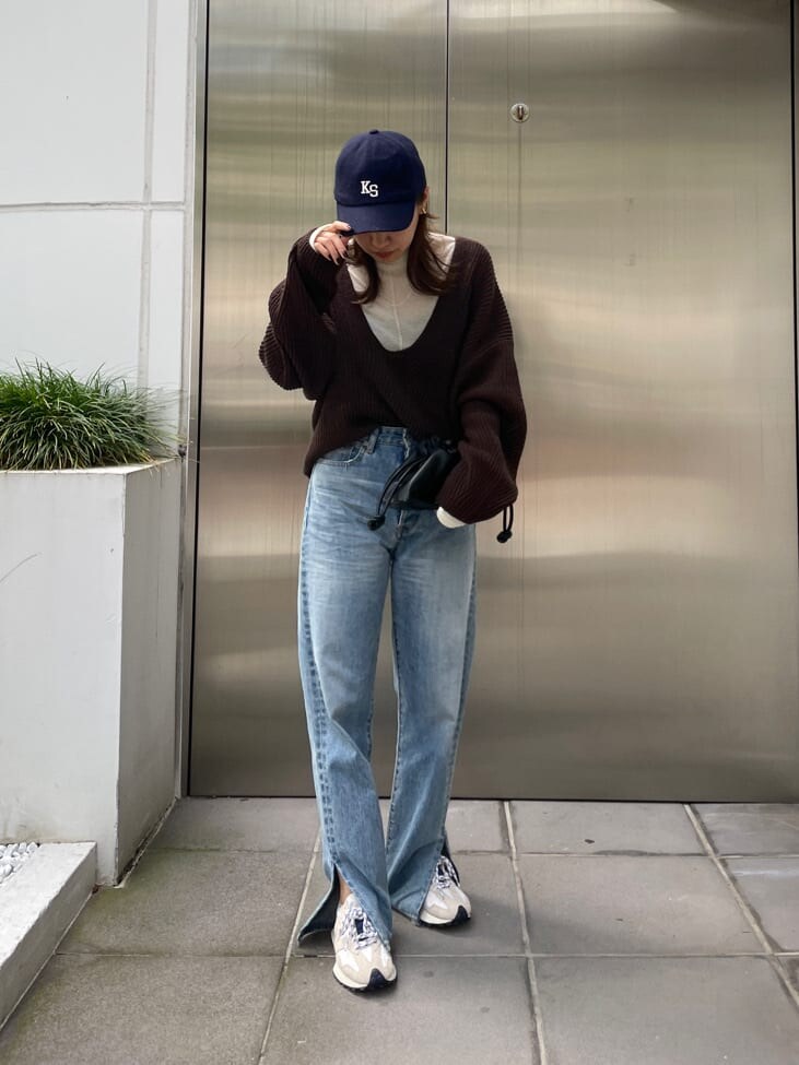 ブラック系のクラッチバッグ、ブルー系のデニムパンツ、ブルー系のデニムパンツを着用したレディースの秋コーディネートの2枚目の写真