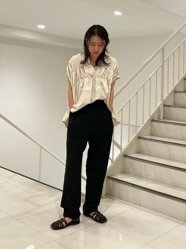 ブラック系のスラックス、ホワイト系のシャツ/ブラウスを着用したレディースの夏コーディネートの2枚目の写真