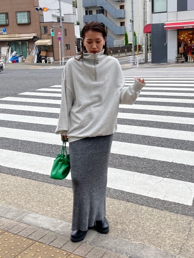 グリーン系のクラッチバッグ、グレー系のスウェット、グレー系のスカートを着用したレディースの秋コーディネートの4枚目の写真